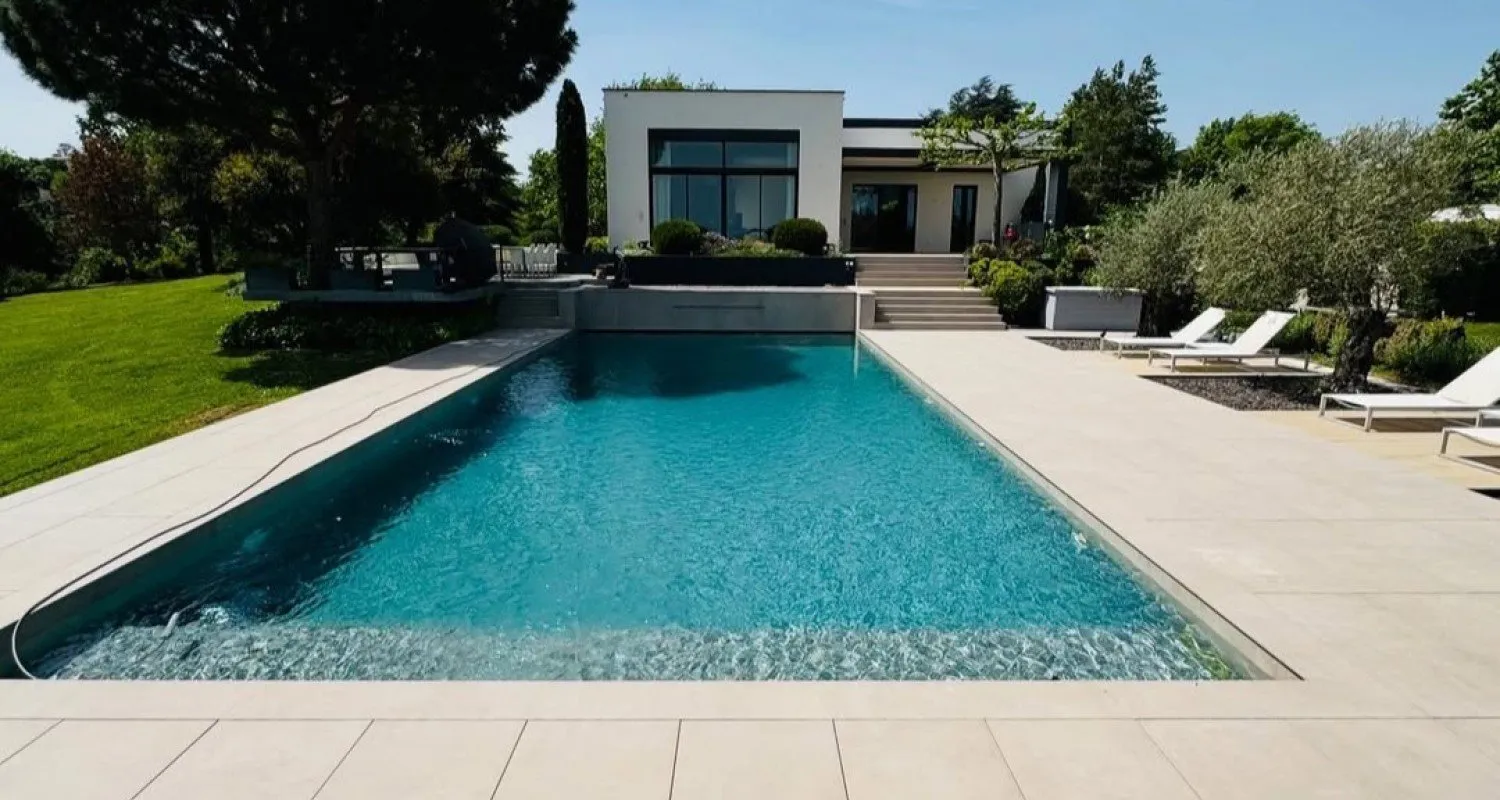 Piscine contemporaine à fond sombre devant une maison moderne